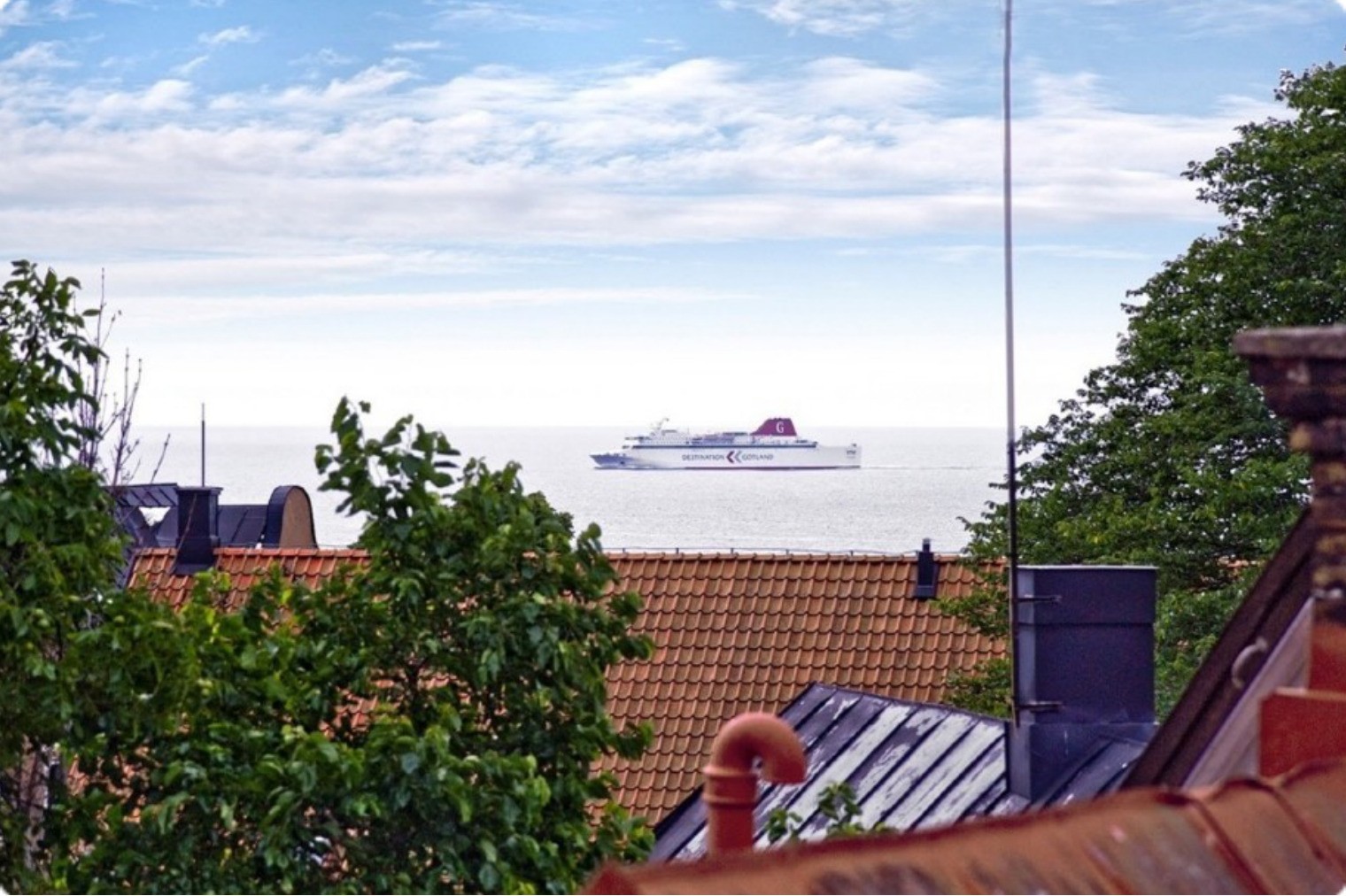 Stadshus med trädgård och havsutsikt innanför muren